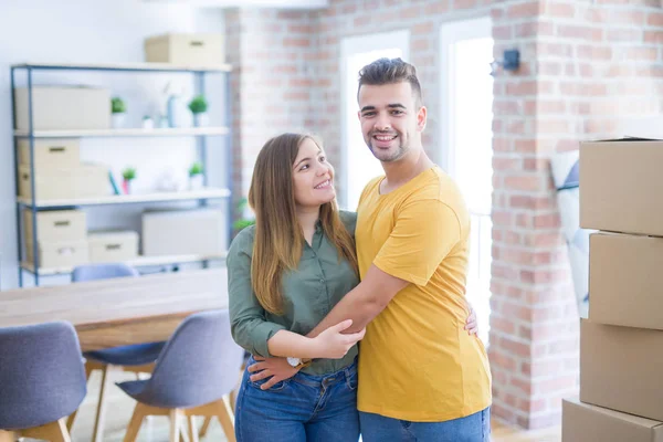 年轻美丽的夫妇在爱周围的纸板箱搬到新家 微笑很高兴和欢快的新公寓 — 图库照片
