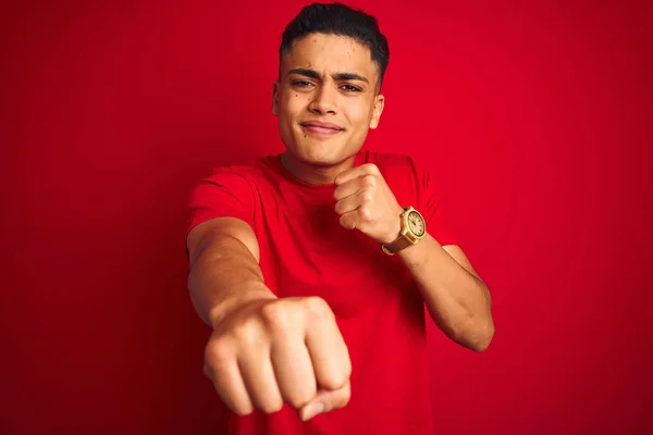 孤立した赤い背景の上に立つTシャツを着た若いブラジル人男性は 戦うために拳をパンチし 攻撃的で怒っている攻撃 脅威と暴力 — ストック写真
