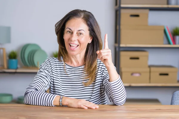 Seniorin Mittleren Alters Sitzt Hause Tisch Und Zeigt Mit Erhobenem — Stockfoto