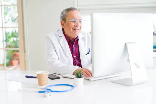 Starszy lekarz mężczyzna w klinice pracy z komputerem i szczęśliwy — Zdjęcie stockowe