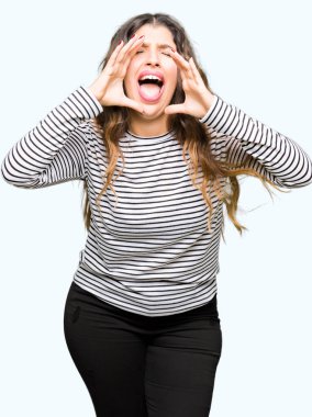 Çizgili süveter ağzına sesle elleriyle kızgın bağırarak giyen genç güzel kadın