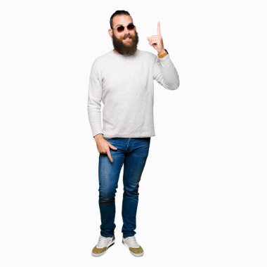 Genç hipster adam başarılı fikirle parmak işaret güneş gözlüğü takıyor. Çıktıktan ve mutlu. Bir numara.