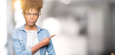 Güzel genç Afro-Amerikan kadın gözlük izole üzerinde işaretleme için reklam, ciddi ve sakin yüz gösterilen yan el parmak ile arka plan