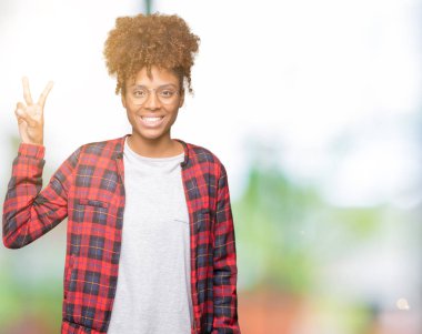 Güzel genç Afro-Amerikan kadın gözlük gösterilen ve parmakları ile işaret izole arka plan üzerinde kendinden emin ve mutlu gülümseyerek iken ikincisi.