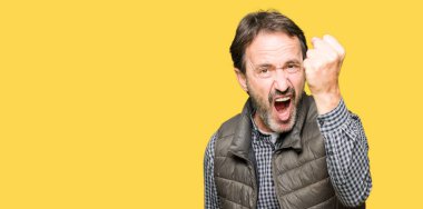 Orta Çağ yakışıklı adam kış yelek giyiyor öfkeli ve deli yükseltme yumruk sinirli ve öfkeli çığlık sırasında öfke. Öfke ve agresif kavram.