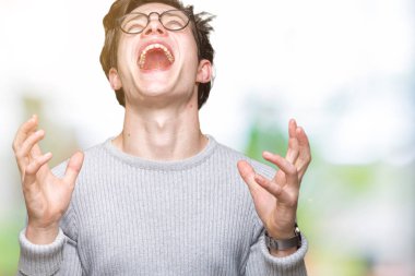 Üzerinde gözlük takan genç yakışıklı adam arka plan deli izole ve deli bağırarak ve agresif ifade ve silah kaldırdı bağırıyor. Hayal kırıklığı kavramı.