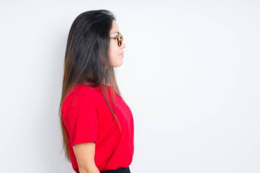 Güzel esmer kadın yan arıyor izole arka plan üzerinde gözlük giyiyor, profil kendine güvenen gülümseme ile doğal yüz ile poz rahatlayın.