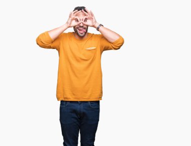 Yakışıklı delikanlı, dilini parmaklarının arasından baktığını yapışmasını dürbün gibi ok jest yapıyor izole arka plan üzerinde. Deli ifade.