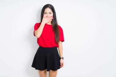 Kırmızı t-shirt ve etek giyen güzel esmer kadın izole arka plan üzerinde el ile ağız kapsayan yorgun esneme sıkılmış. Huzursuz ve uykululuk.