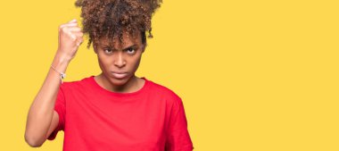 Güzel genç Afro-Amerikan kadın izole arka plan öfkeli ve sinirli sinirli ve öfke ile bağırarak süre öfkeli yumruk yükselterek yüzünden. Öfke ve agresif kavramı.