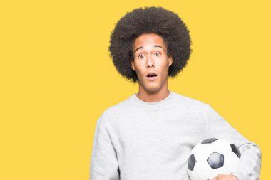 Futbol futbol topu bir sürpriz yüz, korkuyor ve heyecanlı korku ifadesi ile şok korkmuş tutan afro saçlı genç Afro-Amerikan adam