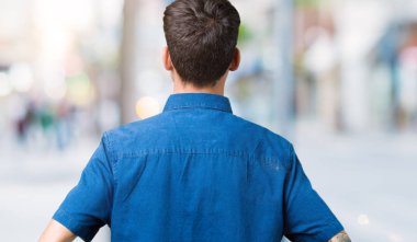 İzole arka plan ayakta geriye doğru uzakta silah ile vücut üzerinde seyir üzerinde gözlük takan genç yakışıklı adam