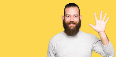 Gösterilen ve parmakları ile işaret rahat kazak giyen genç sarışın adam kendinden emin ve mutlu gülümseyerek süre beş numara.