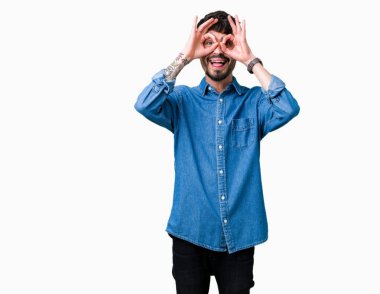 Yakışıklı delikanlı, dilini parmaklarının arasından baktığını yapışmasını dürbün gibi ok jest yapıyor izole arka plan üzerinde. Deli ifade.