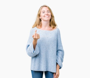 Beckoning gel burada mutlu ve gülümseyerek el davet ile jest izole arka plan üzerinde mavi kazak giyen güzel genç kadın