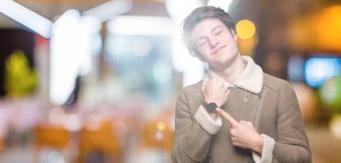 Acele işaretleme izlemek için zaman, sabırsızlık, üzgün ve kızgın son tarih gecikme için arka plan üzerinde kış ceket giyen genç yakışıklı adam izole