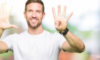 Yakışıklı adam gösterilen ve parmakları ile işaret casual beyaz t-shirt giyen numara 9 kendinden emin ve mutlu gülümseyerek süre.