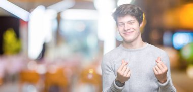 Maaş ödeme için milyoner iş soran izole arka plan yapıyor para hareketi el ile üzerinden kış kazak giyen genç yakışıklı adam