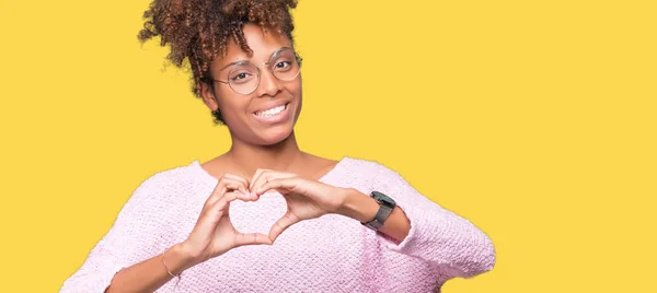 美しい若いアフリカ系アメリカ人女性の恋ハートマークと手で形を示す笑みを浮かべて分離の背景にメガネを着用します ロマンチックな概念 — ストック写真