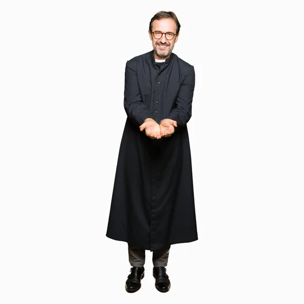 Medelålders Präst Man Klädd Katolska Mantel Leende Med Händerna Handflatorna — Stockfoto