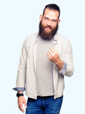 Genç sarışın adam gözlük Beckoning gel burada mutlu ve gülümseyerek el davet ile jest