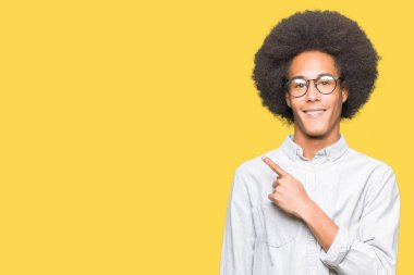 Neşeli bir gülümseme ile el ve parmak kadar yan yüzünde mutlu ve doğal ifade ile işaret yüz ile gözlüklü afro saçlı genç Afro-Amerikan adam