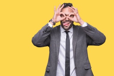 Genç yakışıklı iş adamı, dilini parmaklarının arasından baktığını yapışmasını dürbün gibi ok jest yapıyor izole arka plan üzerinde. Deli ifade.