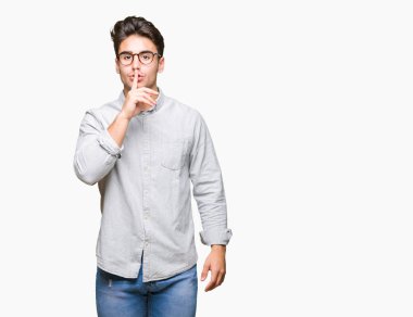 Dudaklarında parmak ile sessiz olmanı izole arka plan üzerinde gözlük takan yakışıklı delikanlı. Sessizlik ve gizli kavramı.