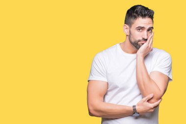 Genç adam izole arka plan üzerinde rahat beyaz t-shirt giyen yorgun görünümlü ve çapraz kolları ile depresyon sorunları ile sıkılmış düşünme.