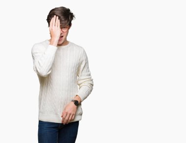 El yüz ve sürpriz duygu kendinden emin gülümseme ile tek gözüyle kapsayan izole arka plan üzerinde gözlük takan genç yakışıklı adam.