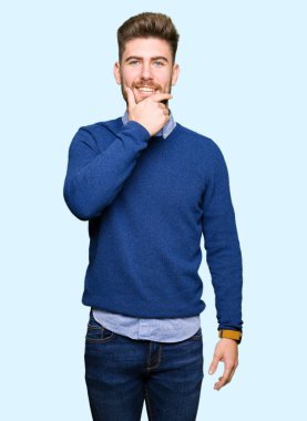 Çapraz kollar ve çeneme kaldırdı el ile gülümseme ile kamera kendinden emin görünen genç yakışıklı iş adam. Pozitif düşünce.