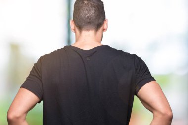 Geriye doğru uzakta silah ile vücut üzerinde seyir izole arka plan ayakta genç yakışıklı adam