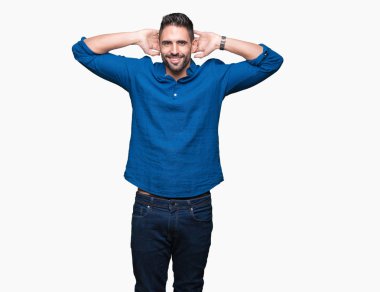 İzole genç yakışıklı adam arka plan dinlenirken ve germe kollar ve eller baş ve boyun arkasında ile mutlu gülümseyerek