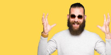 Genç hipster adam kızgın ve silah ile başarı için deli kutluyor güneş gözlüğü takıyor kaldırdı ve heyecanlı çığlık gözler kapalı. Kazanan kavramı