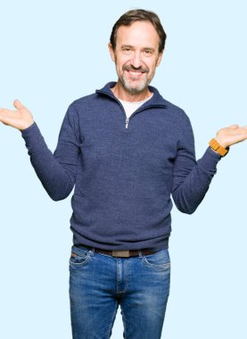 Orta yaş yakışıklı adam bir kazak giyen Gülümseyerek her iki elaçık avuç içi gösteren, sunan ve reklam karşılaştırma ve denge