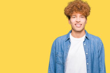 Denim ceket mutlu ve güzel bir gülümseme ile yüzünde afro saçlı Genç yakışıklı adam. Şanslı kişi.