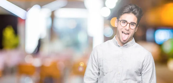 Joven Hombre Guapo Con Gafas Sobre Fondo Aislado Sacando Lengua —  Fotos de Stock