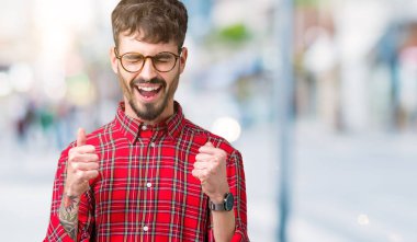 Yakışıklı delikanlı izole arka kolları olan başarı için heyecan üzerinde gözlük takan zafer kutluyor gülümseyen kaldırdı. Kazanan kavramı.