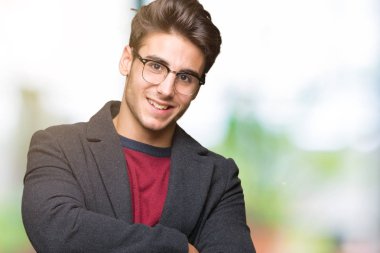 Genç yakışıklı zarif adam gözlüklü üzerinde mutlu yüz ile gülümseyerek kameraya seyir silah geçti arka plan izole. Olumlu bir kişi.