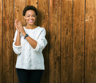 Güzel genç Afro-Amerikan kadın giyiyor kazak izole üzerinde arka plan Clapping ve mutlu ve neşeli, gururlu gülümseyen birlikte eller alkış