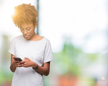 Genç Afro-Amerikan kadın Smartphone akıllı yüzünde ciddi düşünme emin bir ifade ile izole arka plan üzerinde kullanma