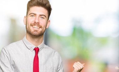 Genç yakışıklı iş arkasından el ve kadar başparmak ile işaret emin gülümseyen adam