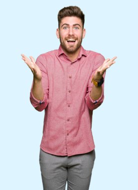 Genç yakışıklı iş casual adam kutluyor deli ve çığlık kaldırdı ve açık gözleri hayret silah ile başarı için heyecanlı. Kazanan kavramı