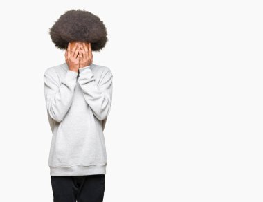 Afrikalı-Amerikalı genç afro saçlı yüz eller ile ağlayarak süre kapsayan üzgün ifade ile sportif kazak giyiyor. Depresyon kavramı.