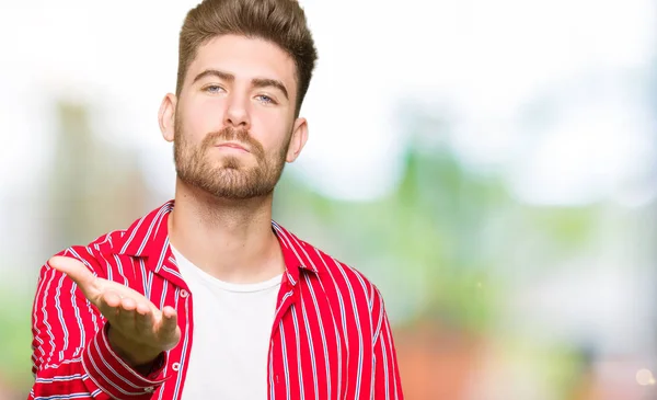 Homem Bonito Jovem Vestindo Camisa Vermelha Olhando Para Câmera Soprando — Fotografia de Stock