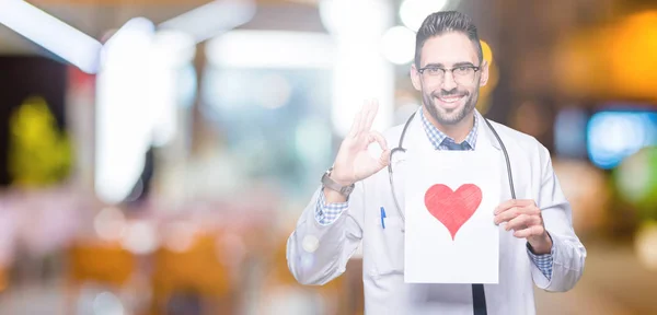 Guapo Joven Doctor Hombre Sosteniendo Papel Con Corazón Rojo Sobre — Foto de Stock