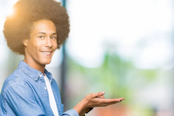 Unga Afroamerikanska Man Med Afrohår Pekar Sidan Med Hand Och — Stockfoto