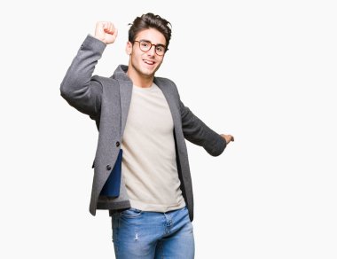 İzole arka plan üzerinde gözlük takan genç iş adamı mutlu ve neşeli dans, eğlenceli hareketli rahat ve müzik dinleme emin