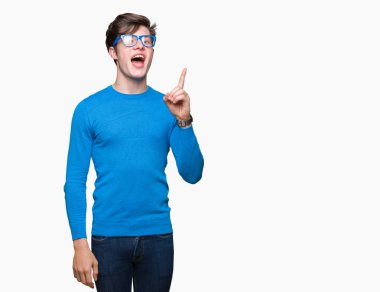 Başarılı fikirle izole arka plan işaret parmağı üzerinde mavi gözlük takan yakışıklı delikanlı. Çıktıktan ve mutlu. Bir numara.