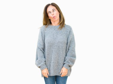 İzole arka plan yapma balık yüzüne dudaklı, çılgın ve komik bir jest kış kazak giyen güzel orta yaş kadın. Komik ifade.